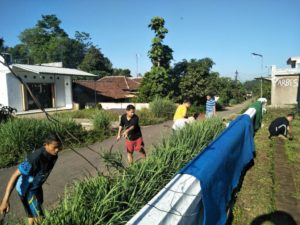 Mahasiswa bersama warga bergotong royong membersihkan lingkungan sekitar